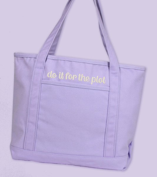 A light purple canvas tote bag with white embroidered text reading 'do it for the plot' on the front pocket, shown against a matching light purple background.